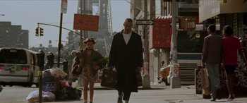Movie still from “Léon: The Professional” (1994), directed by Luc Besson – A man and a woman walking down a street; Wide shot, Low angle