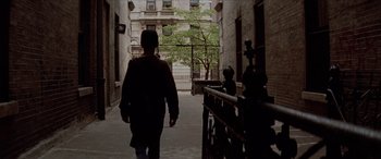 Movie still from “Léon: The Professional” (1994), directed by Luc Besson – A man walking down a street in a city; Wide shot, High angle