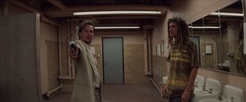 Movie still from “Léon: The Professional” (1994), directed by Luc Besson – A man holding a gun in front of another man in a room; Medium shot, Low angle