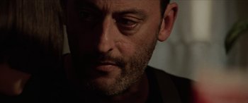 Movie still from “Léon: The Professional” (1994), directed by Luc Besson – A man's face in a dimly - lit room; Close Up shot, Low angle