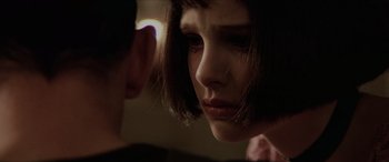 Movie still from “Léon: The Professional” (1994), directed by Luc Besson – A young woman looking at a young man in a dark room; Close Up shot, Over the shoulder angle