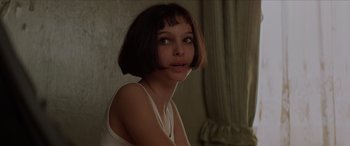Movie still from “Léon: The Professional” (1994), directed by Luc Besson – A woman with short brown hair is looking at the camera; Close Up shot, Over the shoulder angle