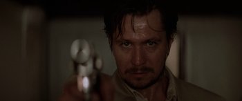 Movie still from “Léon: The Professional” (1994), directed by Luc Besson – A person holding a gun; Close Up shot, Low angle