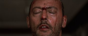 Movie still from “Léon: The Professional” (1994), directed by Luc Besson – A person with a face covered in blood; Extreme Close Up shot, Overhead angle