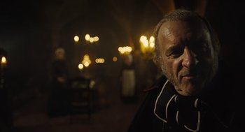 Movie still from “Les Misérables” (2012), directed by Tom Hooper – An old man with a beard is looking at the camera; Close Up shot, Over the shoulder angle