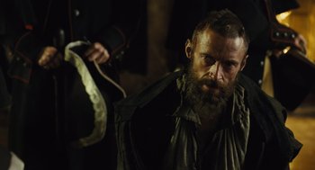 Movie still from “Les Misérables” (2012), directed by Tom Hooper – A man with a long beard is holding something in his hand; Close Up shot, Over the shoulder angle