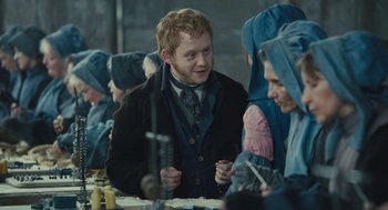 Movie still from “Les Misérables” (2012), directed by Tom Hooper – A group of people sitting around a table; Medium shot, Over the shoulder angle