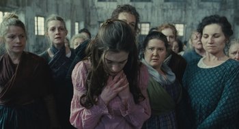 Movie still from “Les Misérables” (2012), directed by Tom Hooper – A group of people standing in a room; Medium shot, Over the shoulder angle