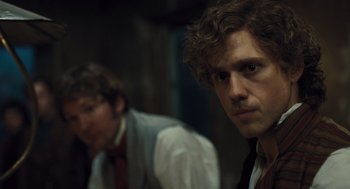 Movie still from “Les Misérables” (2012), directed by Tom Hooper – Two men in suits and ties are looking at the camera; Close Up shot, Over the shoulder angle