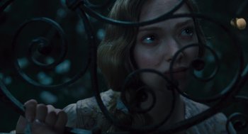 Movie still from “Les Misérables” (2012), directed by Tom Hooper – A young woman looking through a wrought - iron fence; Close Up shot, Over the shoulder angle