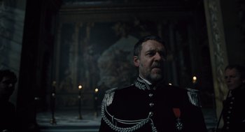 Movie still from “Les Misérables” (2012), directed by Tom Hooper – A man in a military uniform standing in front of a painting; Medium shot, Low angle