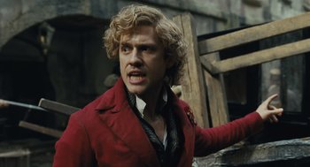 Movie still from “Les Misérables” (2012), directed by Tom Hooper – A man in a red jacket is looking at the camera; Close Up shot, Low angle