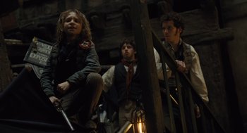 Movie still from “Les Misérables” (2012), directed by Tom Hooper – A group of young people sitting on steps; Medium shot, Low angle