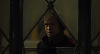 Movie still from “Les Misérables” (2012), directed by Tom Hooper – A man looking through a fence at night time; Close Up shot, Over the shoulder angle