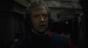 Movie still from “Les Misérables” (2012), directed by Tom Hooper – A person with curly hair wearing a jacket; Close Up shot, Over the shoulder angle