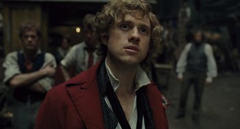 Movie still from “Les Misérables” (2012), directed by Tom Hooper – A person wearing a suit and tie; Close Up shot, Low angle