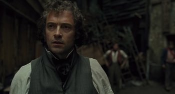 Movie still from “Les Misérables” (2012), directed by Tom Hooper – A person wearing a suit and tie; Close Up shot, Over the shoulder angle