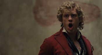 Movie still from “Les Misérables” (2012), directed by Tom Hooper – A man in a red jacket with his mouth wide open; Close Up shot, Low angle