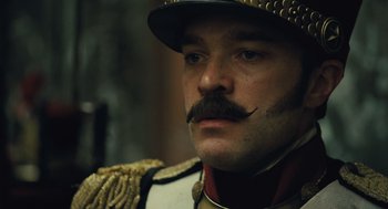 Movie still from “Les Misérables” (2012), directed by Tom Hooper – A person wearing a uniform and a hat; Close Up shot, Low angle