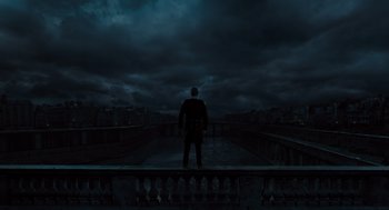 Movie still from “Les Misérables” (2012), directed by Tom Hooper – A man standing on top of a building in the dark; Extreme Wide shot, Low angle