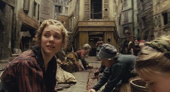 Movie still from “Les Misérables” (2012), directed by Tom Hooper – A group of people in the middle of an alleyway; Medium shot, Over the shoulder angle
