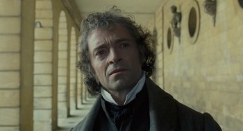 Movie still from “Les Misérables” (2012), directed by Tom Hooper – A person wearing a suit and tie; Close Up shot, Over the shoulder angle