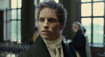 Movie still from “Les Misérables” (2012), directed by Tom Hooper – A person wearing a suit and tie; Close Up shot, Over the shoulder angle