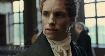 Movie still from “Les Misérables” (2012), directed by Tom Hooper – A person wearing a suit and tie; Close Up shot, Over the shoulder angle