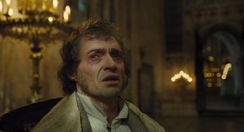 Movie still from “Les Misérables” (2012), directed by Tom Hooper – A person wearing a suit and tie; Close Up shot, Low angle