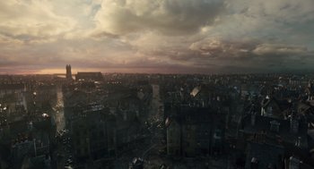 Movie still from “Les Misérables” (2012), directed by Tom Hooper – An aerial view of a city with a cloudy sky above it; Extreme Wide shot, High angle