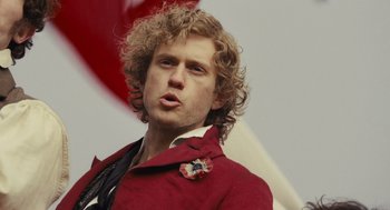 Movie still from “Les Misérables” (2012), directed by Tom Hooper – A person wearing a red jacket; Close Up shot, Low angle