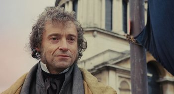 Movie still from “Les Misérables” (2012), directed by Tom Hooper – A person with curly grey hair; Close Up shot, Low angle