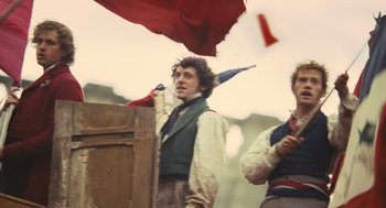 Movie still from “Les Misérables” (2012), directed by Tom Hooper – A man in a vest holding an open umbrella; Medium shot, Low angle