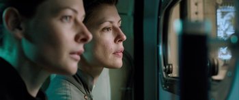 Movie still from “Life” (2017), directed by Daniel Espinosa – A woman looking in a mirror while standing next to another woman; Close Up shot, Low angle
