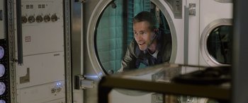 Movie still from “Life” (2017), directed by Daniel Espinosa – A man is looking into a round mirror; Close Up shot, Over the shoulder angle