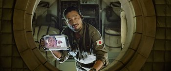 Movie still from “Life” (2017), directed by Daniel Espinosa – A man holding up a tablet computer in front of a mirror; Close Up shot, Overhead angle