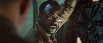 Movie still from “Life” (2017), directed by Daniel Espinosa – A person wearing glasses and a jacket; Close Up shot, Low angle