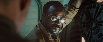 Movie still from “Life” (2017), directed by Daniel Espinosa – A person wearing glasses and a jacket; Close Up shot, Low angle