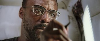 Movie still from “Life” (2017), directed by Daniel Espinosa – A person wearing glasses; Close Up shot, Low angle