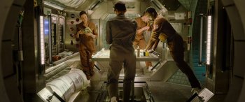 Movie still from “Life” (2017), directed by Daniel Espinosa – A group of people in a room with a table; Wide shot, Overhead angle