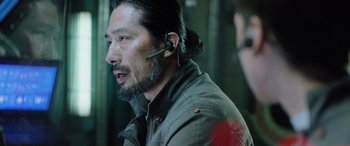 Movie still from “Life” (2017), directed by Daniel Espinosa – A man with a beard wearing a wireless headset; Close Up shot, Over the shoulder angle