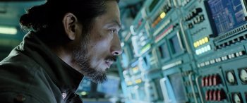 Movie still from “Life” (2017), directed by Daniel Espinosa – A person with a beard looking to the side; Close Up shot, Low angle