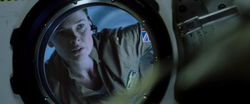 Movie still from “Life” (2017), directed by Daniel Espinosa – A woman is looking into a round mirror; Close Up shot, Overhead angle