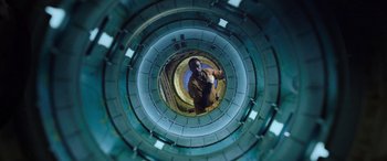 Movie still from “Life” (2017), directed by Daniel Espinosa – A man standing inside of a building looking up; Wide shot, Overhead angle