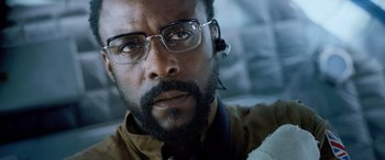 Movie still from “Life” (2017), directed by Daniel Espinosa – A person wearing glasses; Close Up shot, Low angle