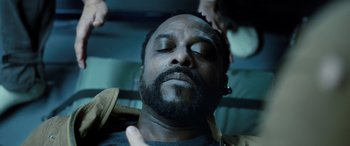 Movie still from “Life” (2017), directed by Daniel Espinosa – A man with his eyes closed is laying down; Close Up shot, High angle