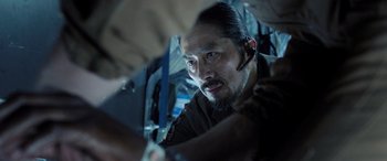 Movie still from “Life” (2017), directed by Daniel Espinosa – A person with a beard looking at the camera; Close Up shot, Over the shoulder angle