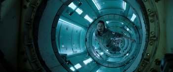 Movie still from “Life” (2017), directed by Daniel Espinosa – A man is inside of an empty space station; Wide shot, Overhead angle