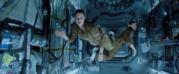 Movie still from “Life” (2017), directed by Daniel Espinosa – A man in a brown uniform is in the air; Medium shot, Overhead angle