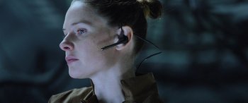Movie still from “Life” (2017), directed by Daniel Espinosa – A woman wearing a pair of ear buds with wires attached; Close Up shot, Over the shoulder angle